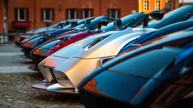 Close-up of exotic supercars parked in an outdoor urban area.