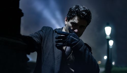 Free A dark, mysterious portrait of a man under a streetlamp at night. Stock Photo