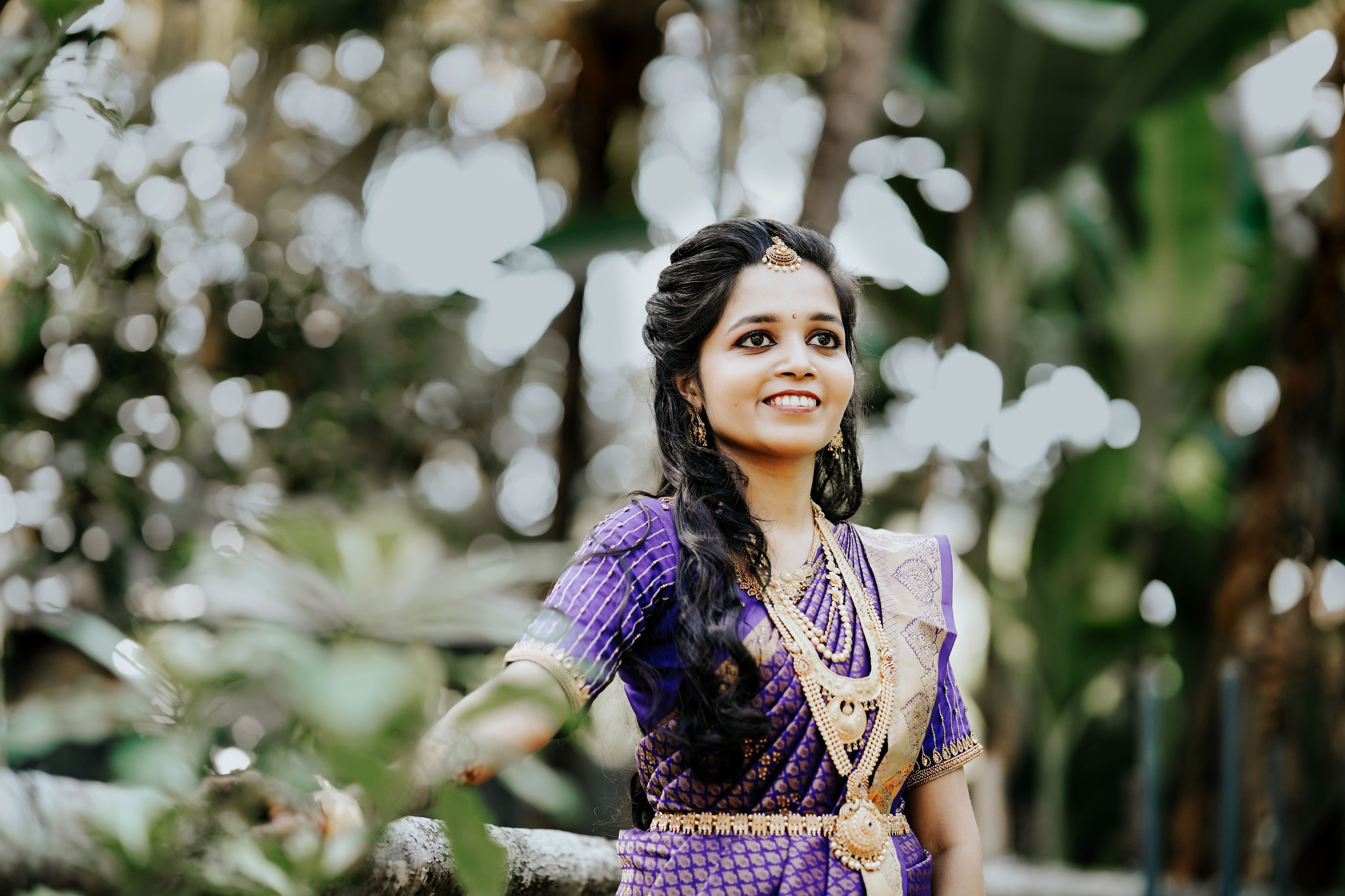 Smiling South Asian bride in vibrant attire posing outdoors in Kanniyakumari, Tamil Nadu.