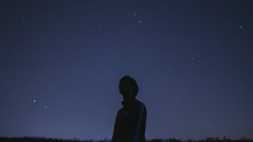 бесплатная Силуэт человека, стоящего под звездной ночью Стоковое фото