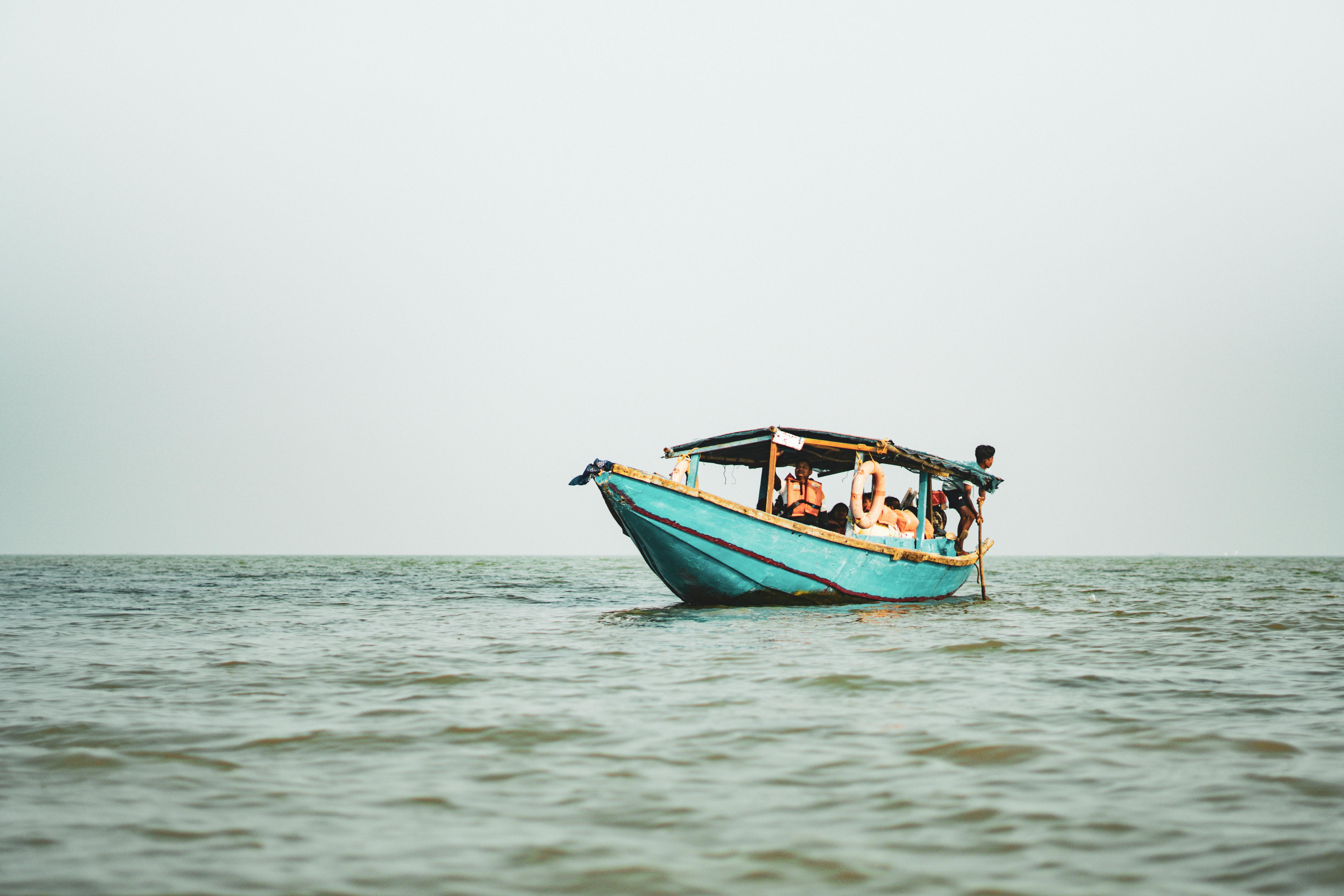 A serene boat with passengers floating on calm waters, creating a peaceful scene.