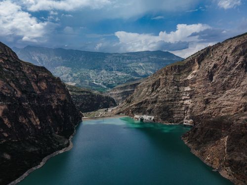 Free Aerial view of a serene mountain lake surrounded by dramatic cliffs and peaks. Stock Photo