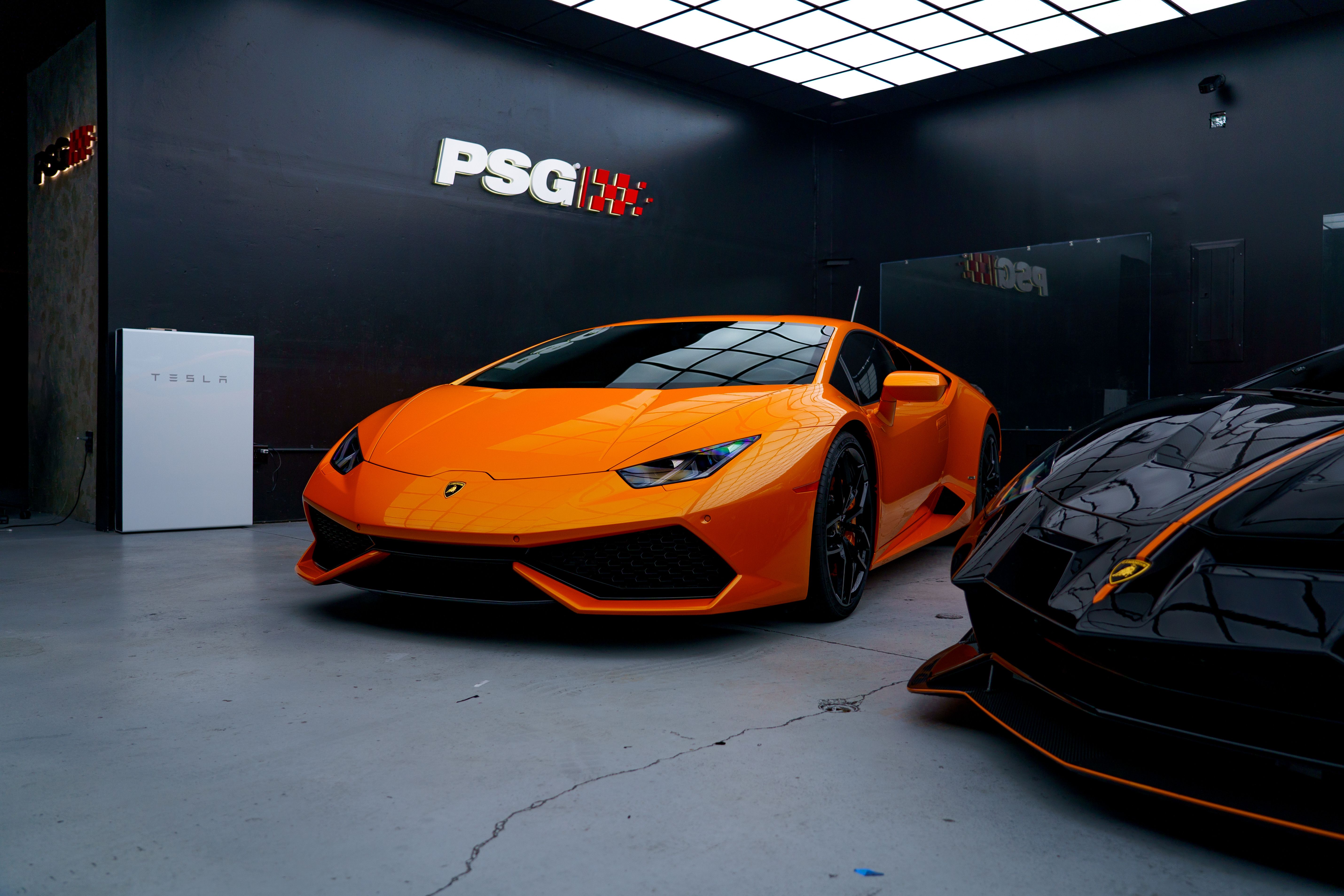 Captivating image of a sleek orange sports car in an indoor garage, perfect for automotive enthusiasts.