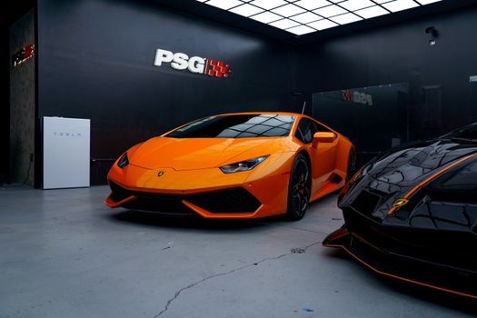 Captivating image of a sleek orange sports car in an indoor garage, perfect for automotive enthusiasts.