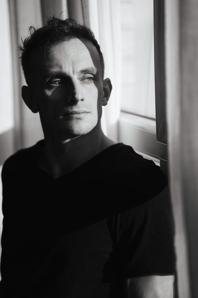 Black and white portrait of a man at a window, photo by Christiyana Krüger on Pexels