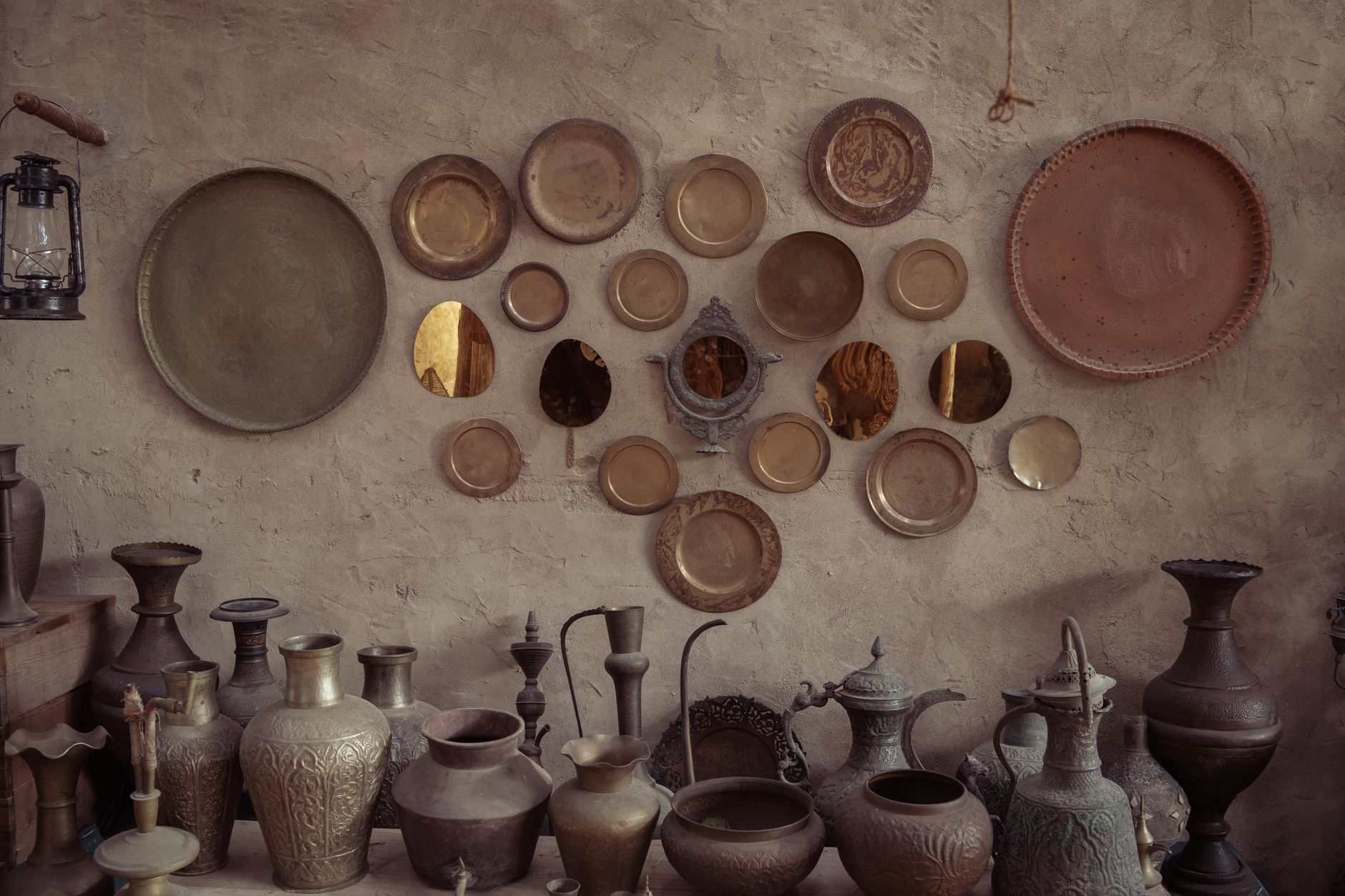 A rustic wall adorned with vintage metal plates and pottery, creating a nostalgic ambiance.