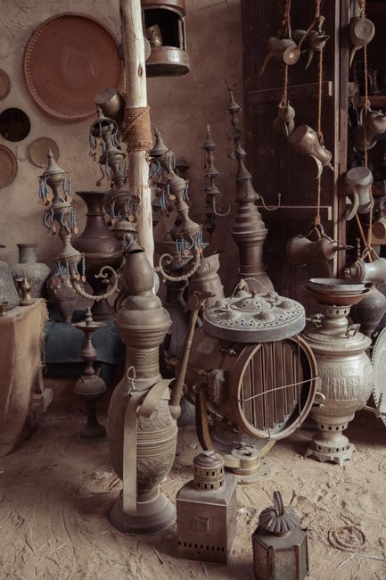 A collection of vintage Middle Eastern antiques and copperware in a rustic indoor setting.