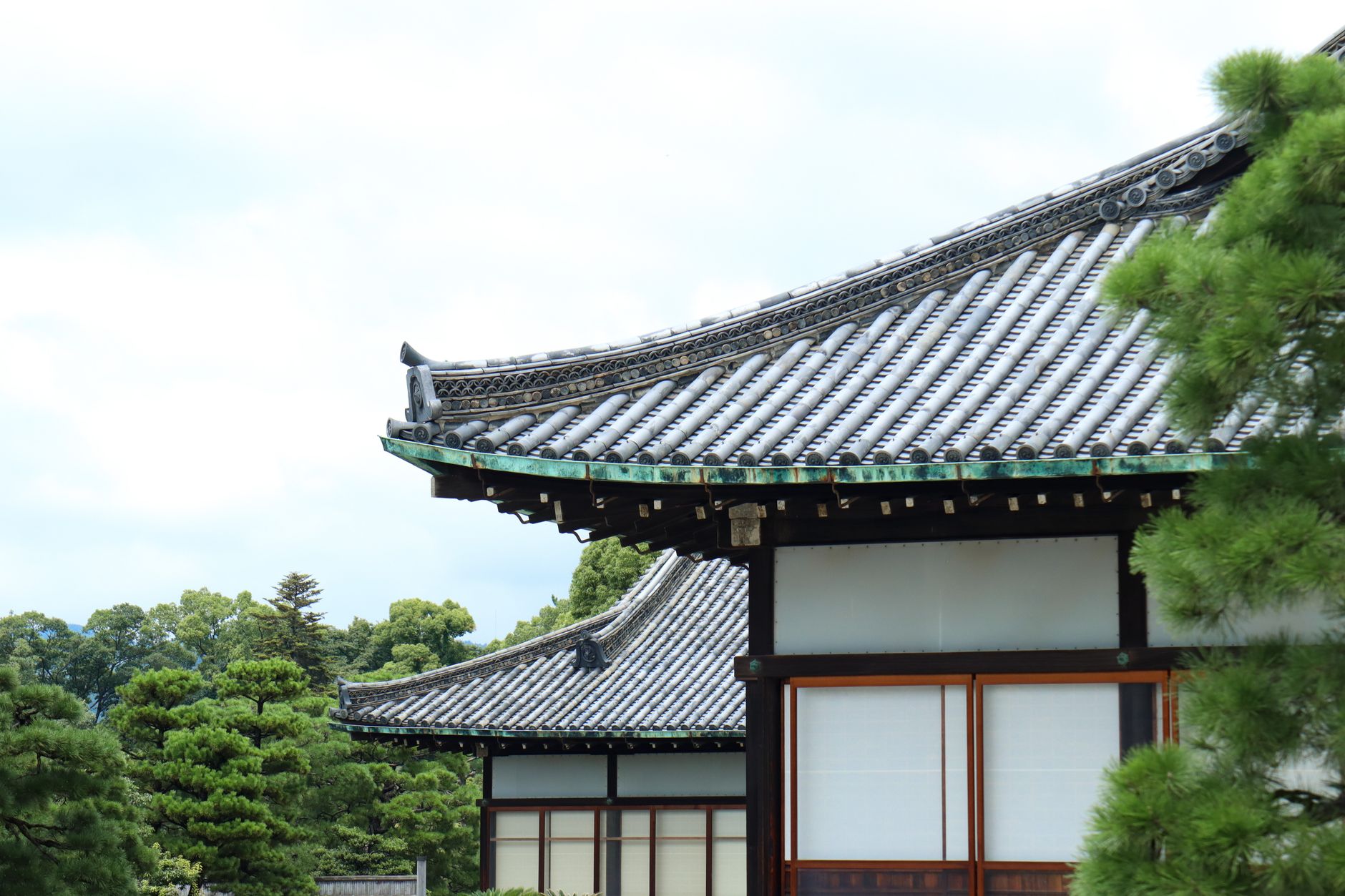 A serene view of a traditional Japanese building with intricate roof design in Kyoto.