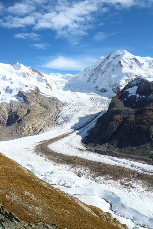Free Stunning view of a glacier flowing through the Swiss Alps, surrounded by towering peaks. Stock Photo