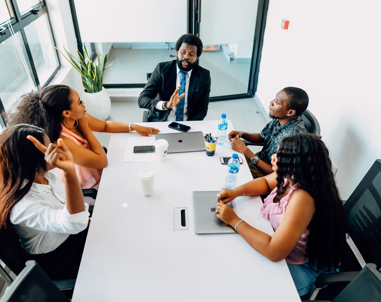 African business leaders collaborating around a laptop in a modern meeting room