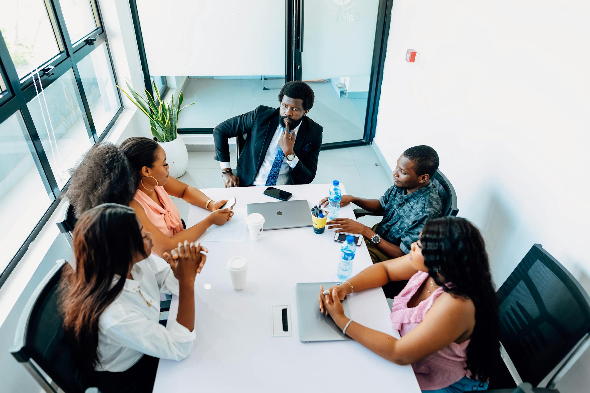 A team and their boss sitting in the conference room and having a meeting. Find more afro-centric images at www.ninthgrid.com