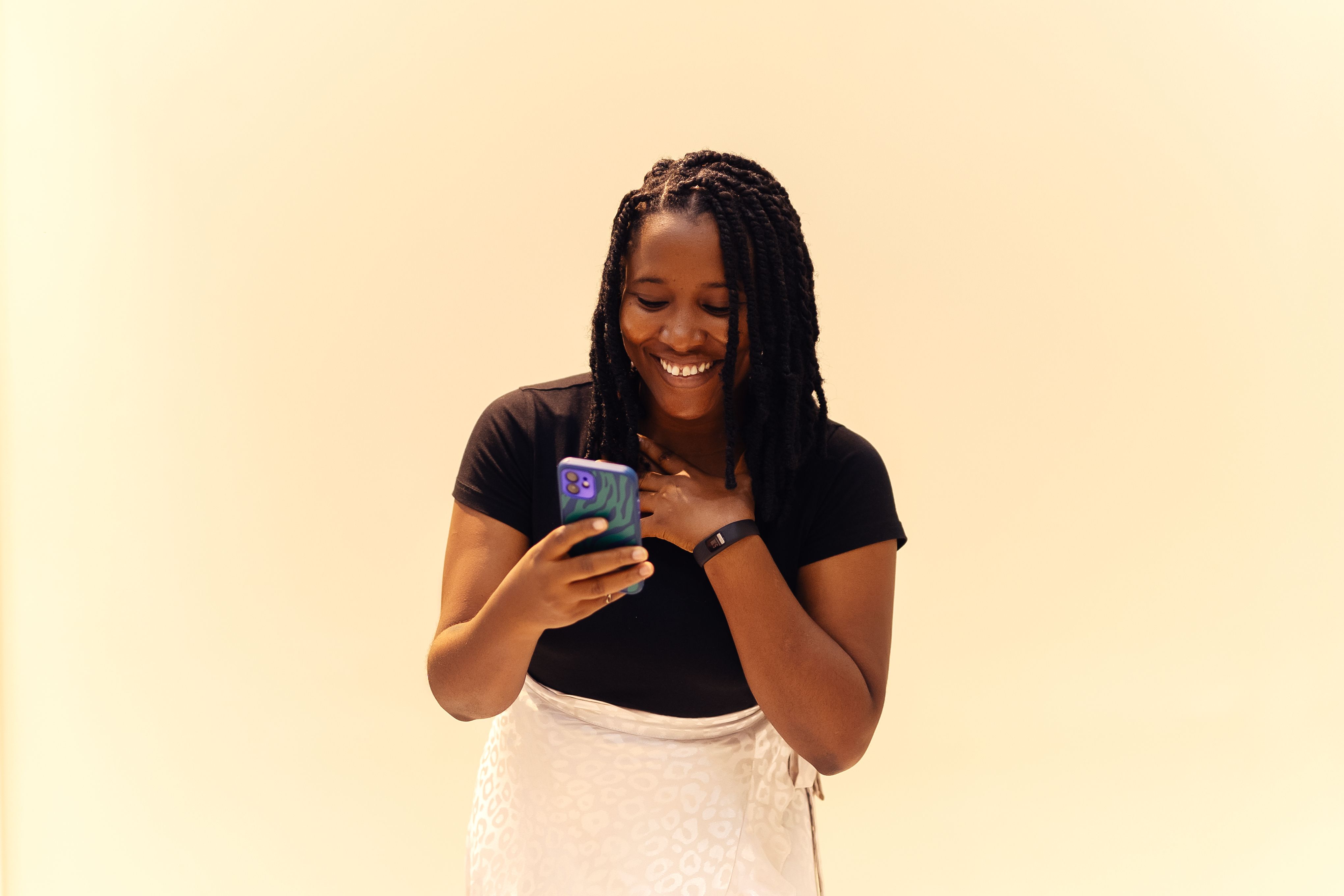 A happy woman in Lagos using her smartphone