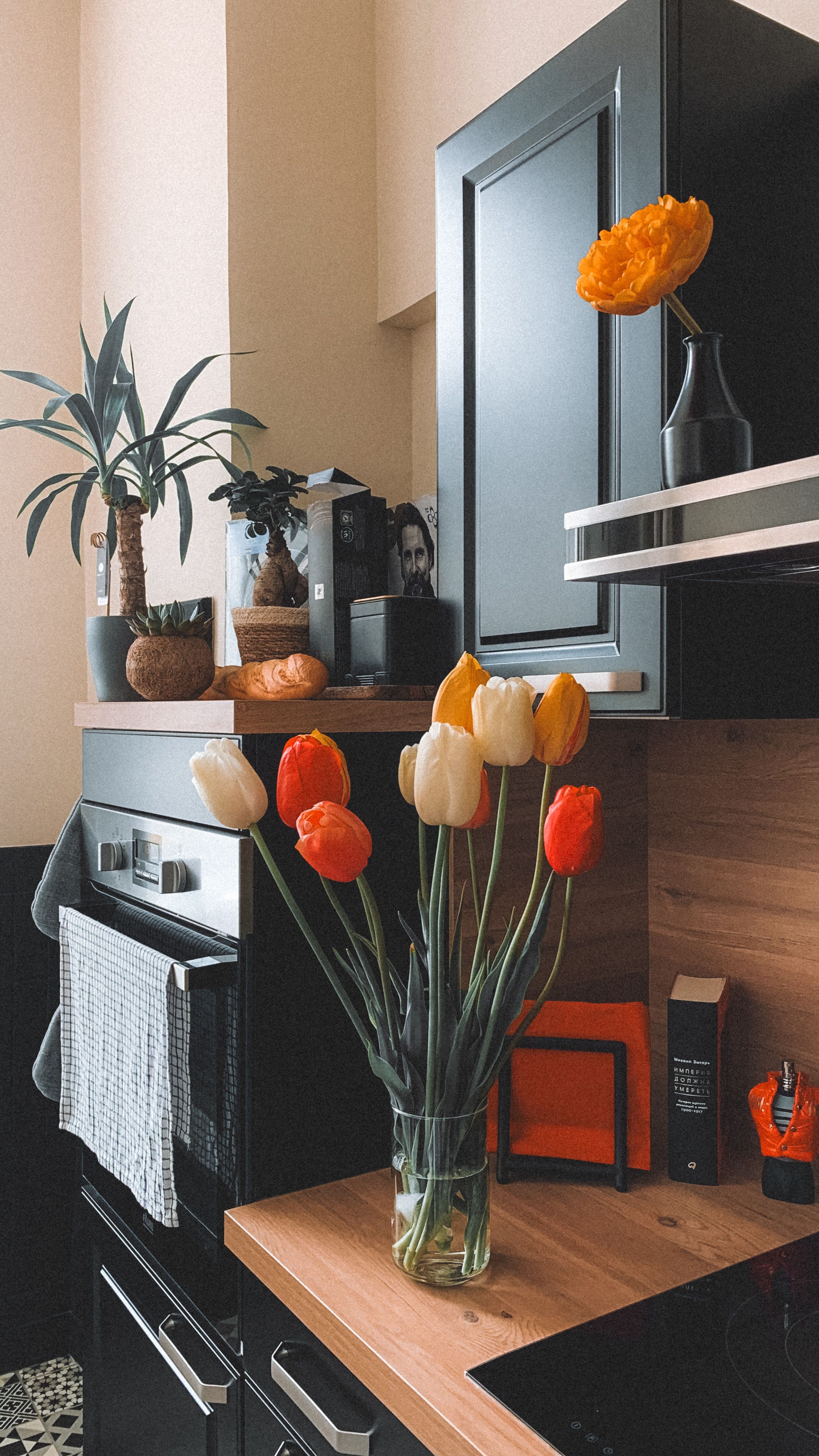 Gemütliche Küche mit leuchtenden Tulpen und modernem Dekor auf einer Holzarbeitsplatte.