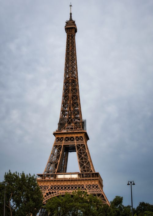 Free Iconic Eiffel Tower against a cloudy Parisian sky, showcasing classic French architecture. Stock Photo