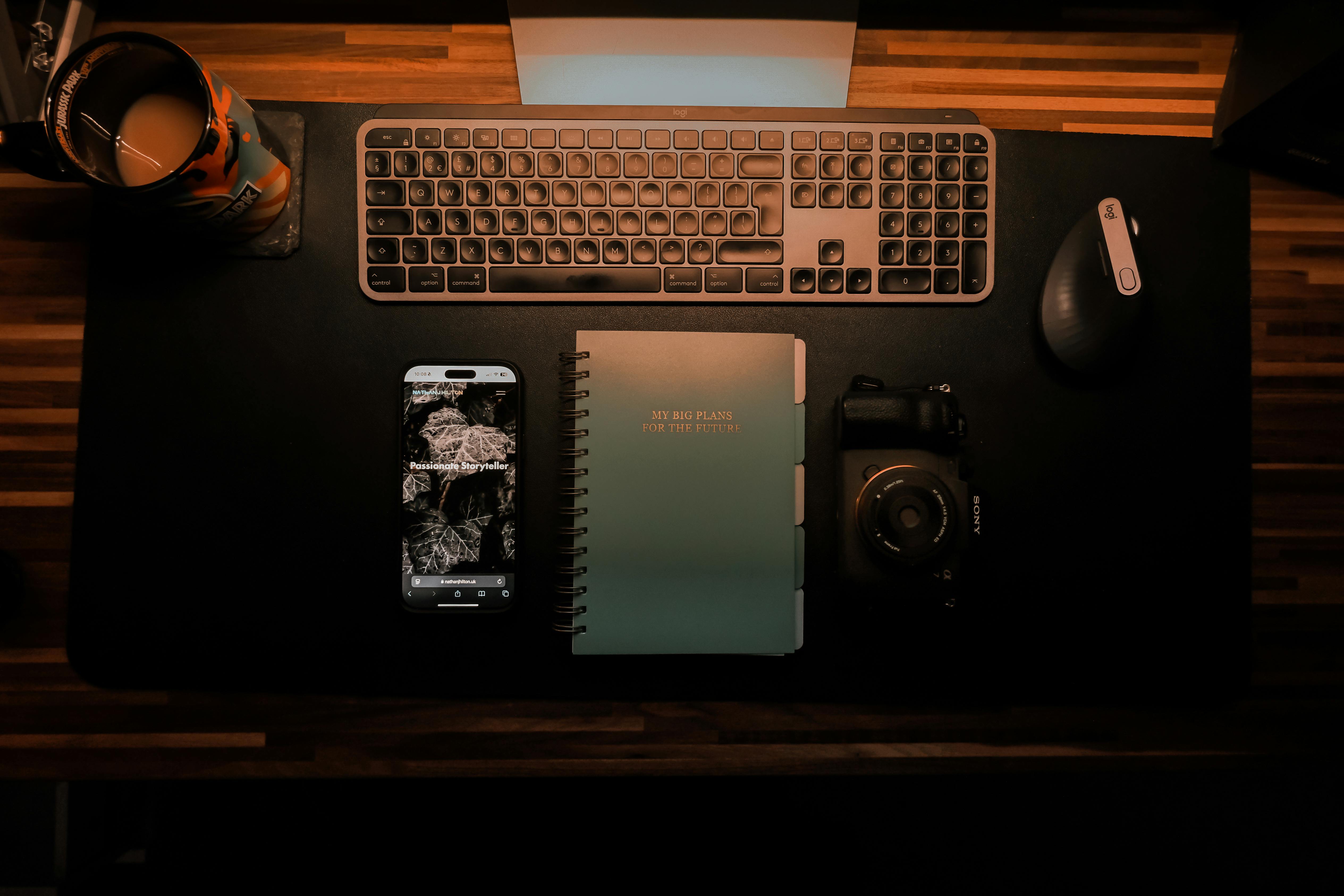 Kostenlos Draufsicht auf einen organisierten Schreibtischaufbau mit Tastatur, Kamera, Notebook und Smartphone für kreative Planung. Stock-Foto