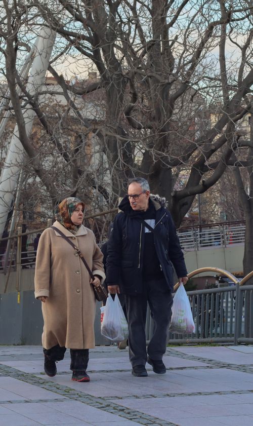 Free Mature couple walking outdoors with shopping bags on a chilly winter day. Stock Photo