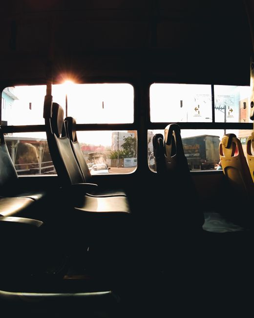Silhouette of bus seats with a warm sunset view through the windows in São Paulo.