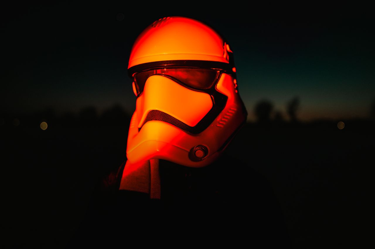 moody night shot of a sci fi helmet illuminated by red light evoking a