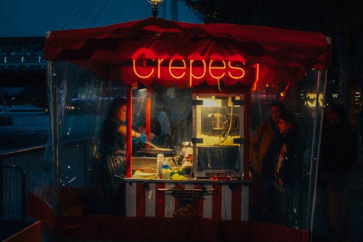 Cinematic view of a crepe stall by the River Thames in London at night.