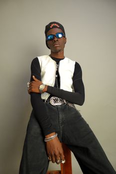 Trendy young man wearing sunglasses and casual fashion, posing confidently.