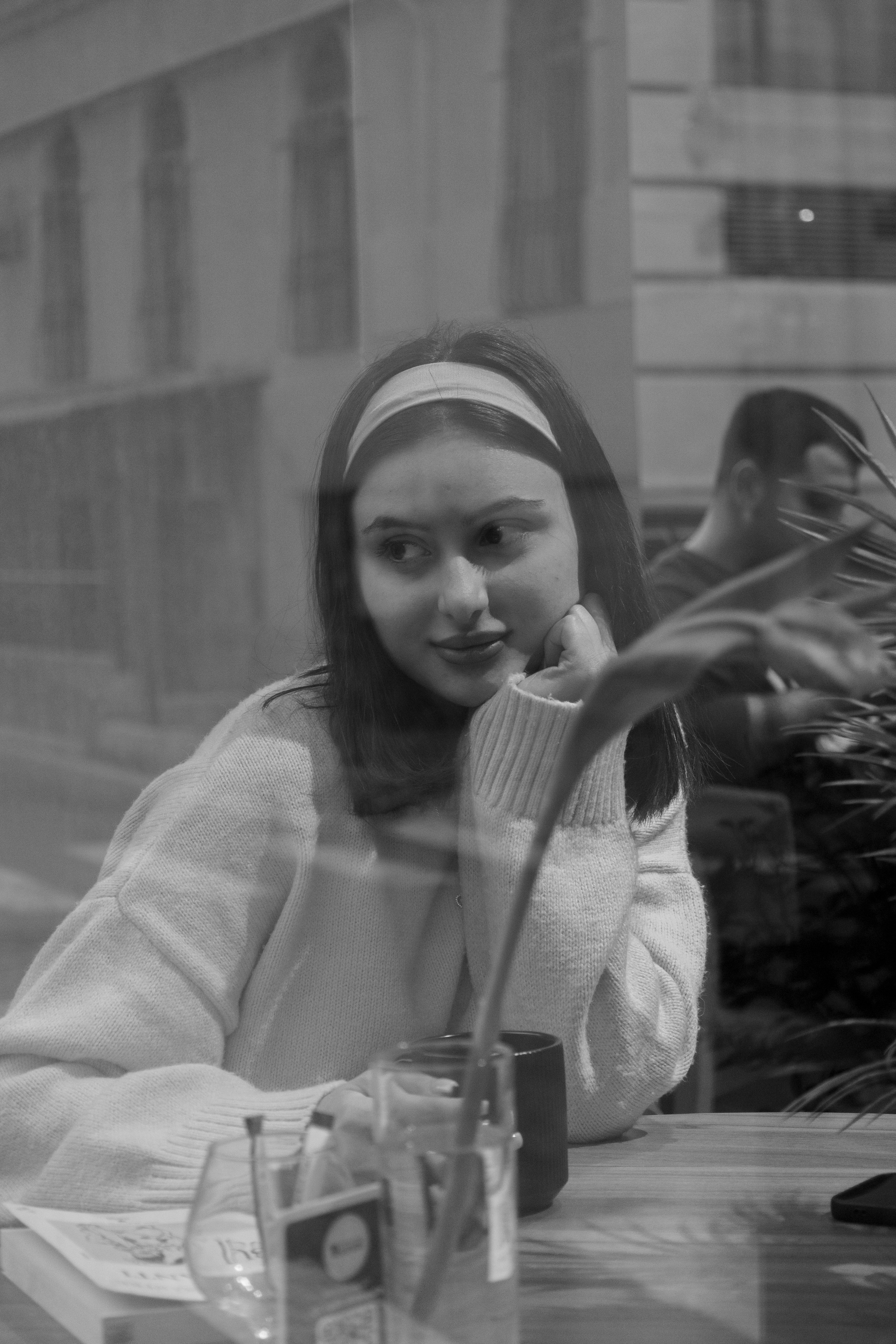 Gratuit Imagine monocromă care surprinde o femeie în reflecție la o cafenea, evocând o dispoziție contemplativă. Fotografie de stoc