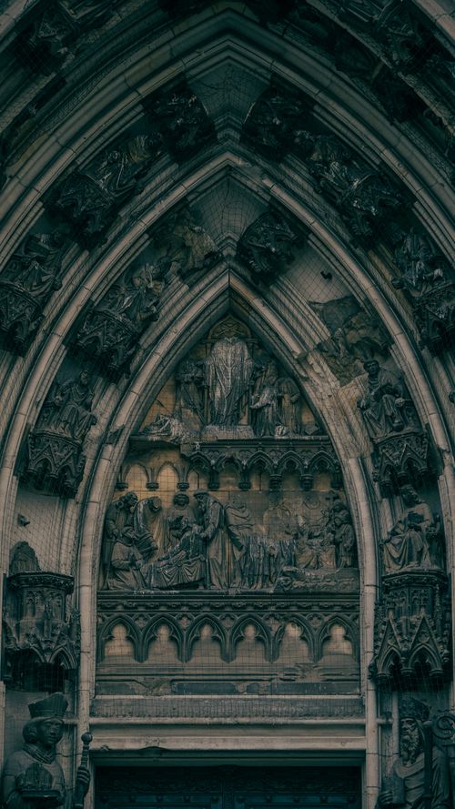 Free Detailed view of a Gothic cathedral entrance featuring intricate stone carvings. Stock Photo
