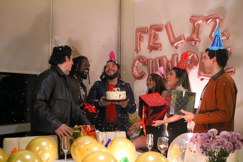 Fotomural Grupo de amigos celebrando un cumpleaños con regalos y pastel en el interior.