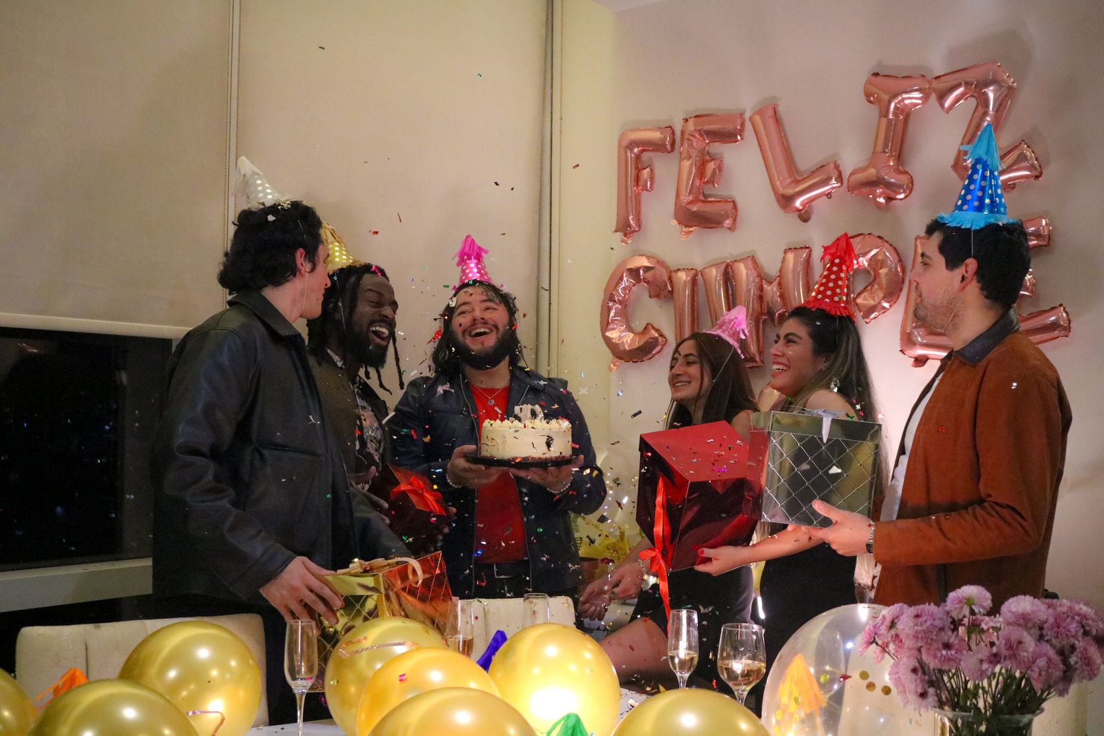 Friends gathered around a cake mid-celebration
