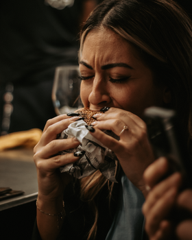 Close-up of a woman savoring a juicy hamburger at a restaurant in Madrid, Spain.