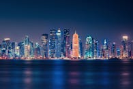 多哈迷人的夜色中，明亮的天际线倒映在水面上