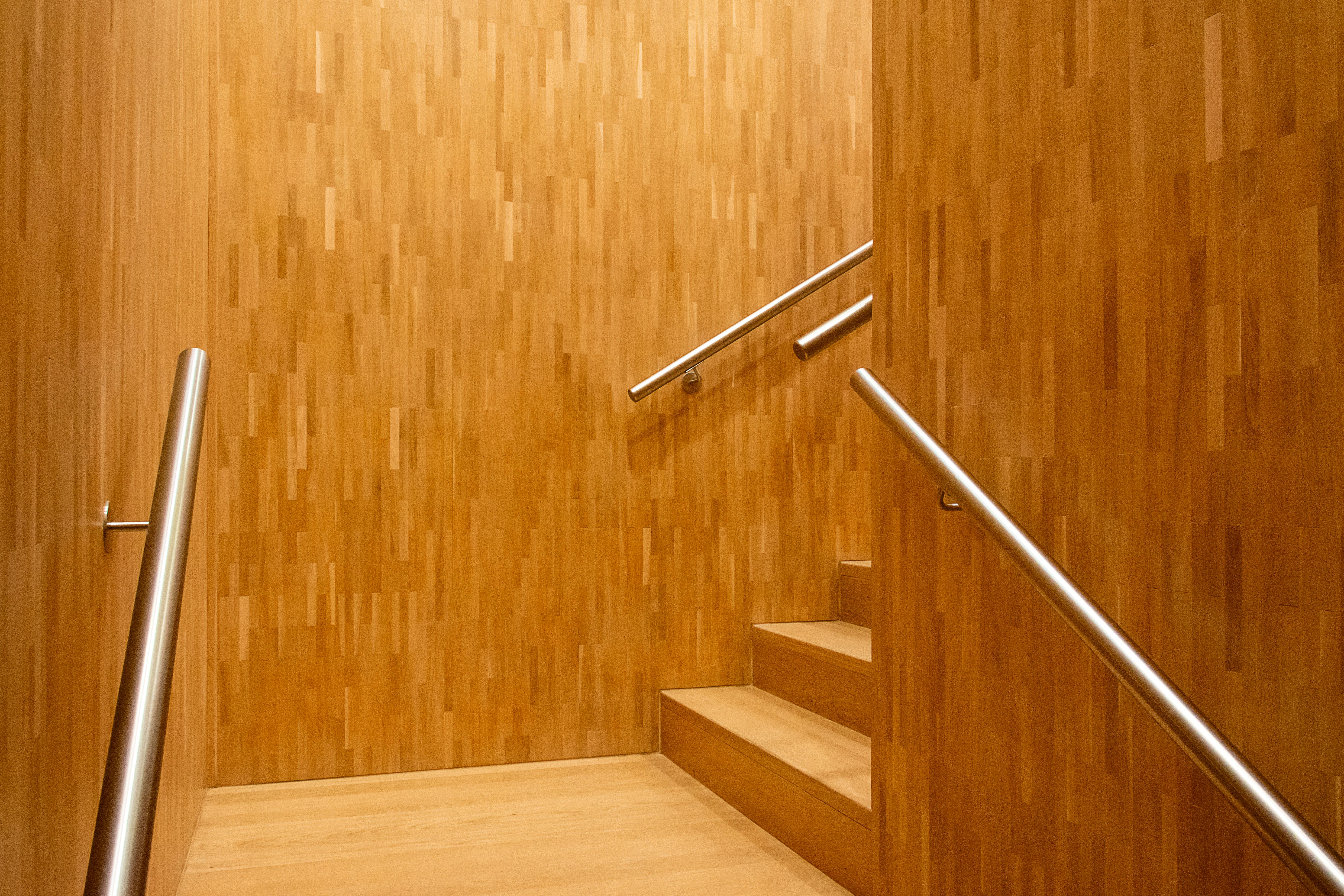A sleek wooden staircase with minimalist design and metal railings, ideal for contemporary interiors.