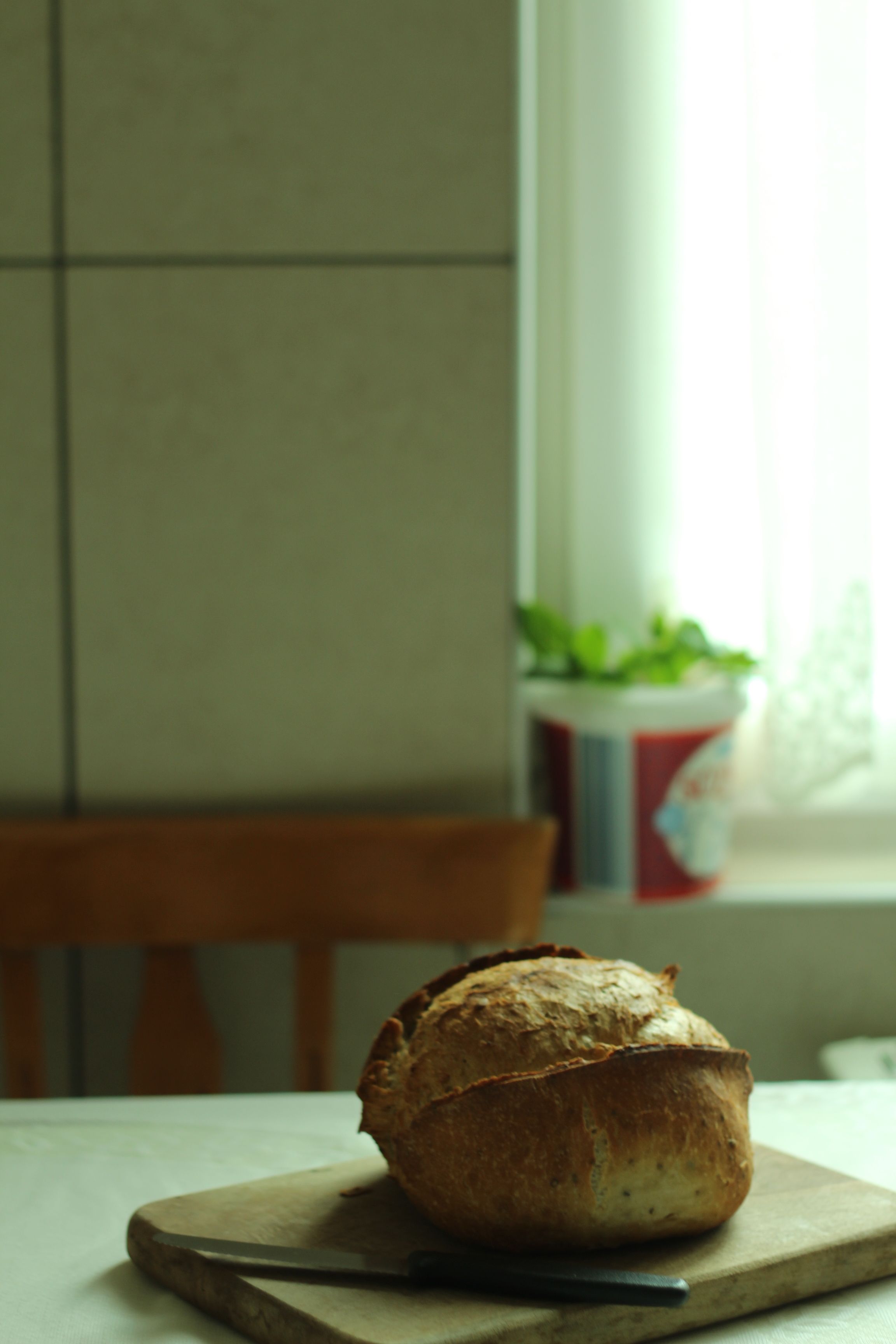Freshly baked bread on a cutting board in a cozy kitchen setting.