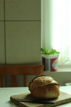 Freshly baked bread on a cutting board in a cozy kitchen setting.