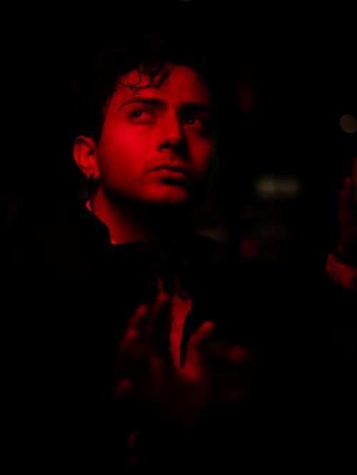 Free A dramatic portrait of a man in red lighting, set against a dark, cinematic background. Stock Photo