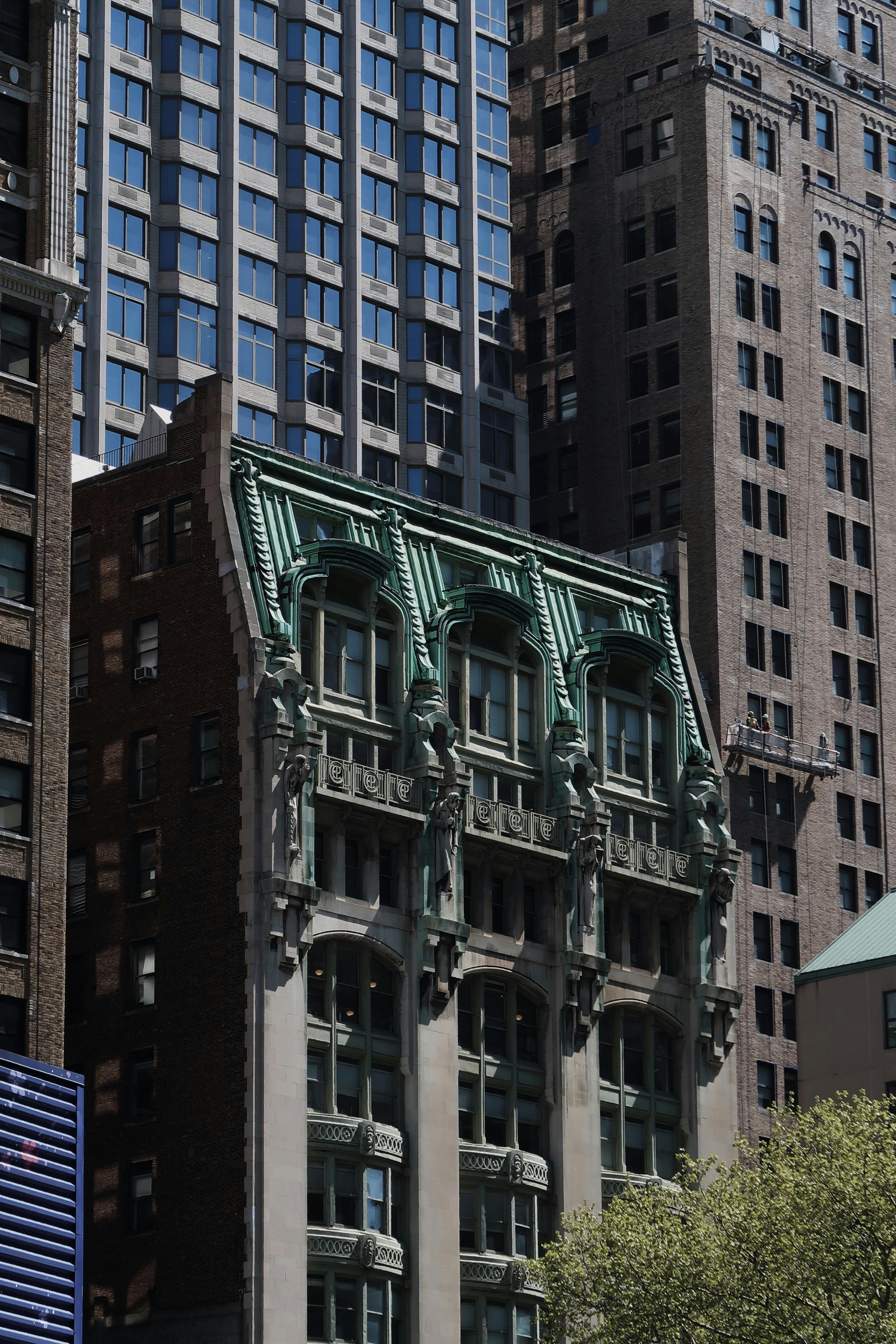 Ornate historic building facade surrounded by modern skyscrapers.