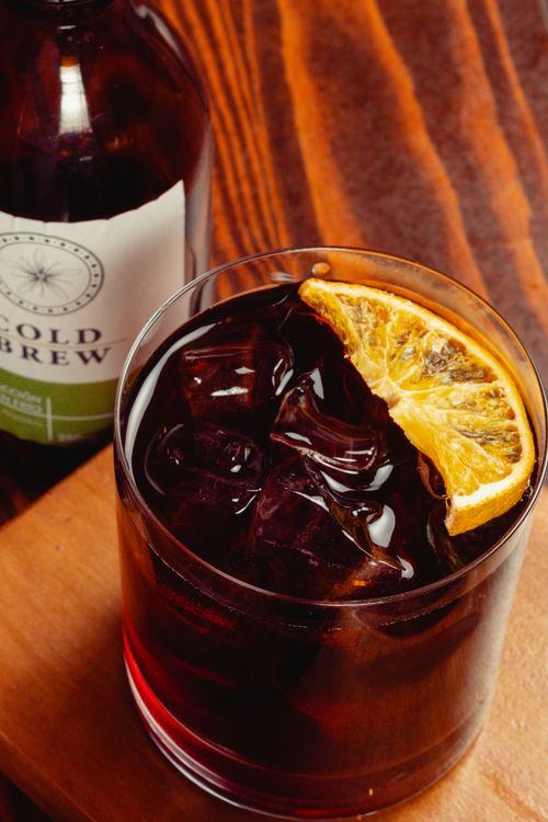 Free Chilled cold brew coffee served with an orange slice, perfect for refreshing moments. Stock Photo