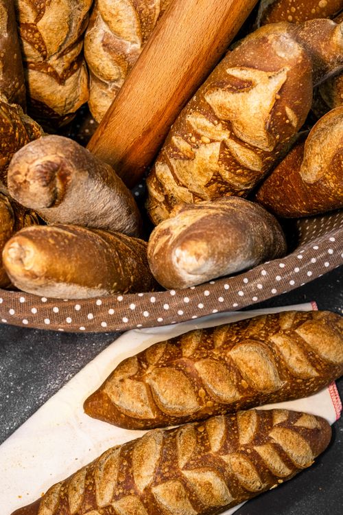 Free Freshly baked artisan baguettes displayed in a polka-dot basket, showcasing rustic bread from Ünye, Türkiye. Stock Photo