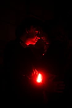 A couple shares an intimate moment under a red light, creating a romantic and mysterious ambiance.