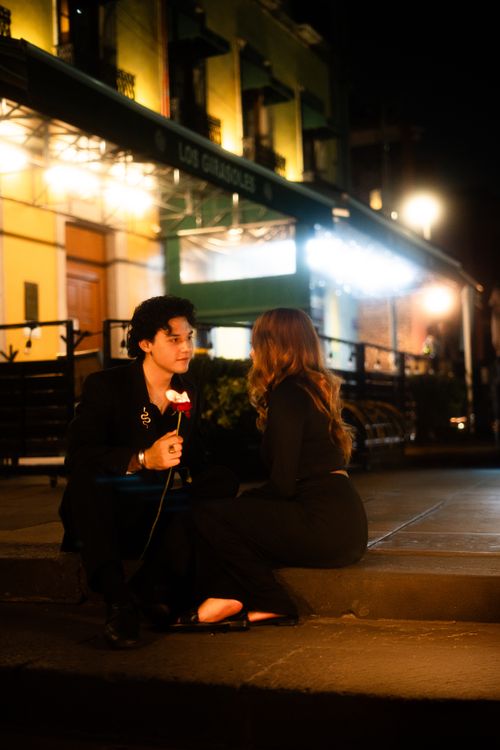 Free A couple shares a romantic moment outside a restaurant in Mexico City at night. Stock Photo