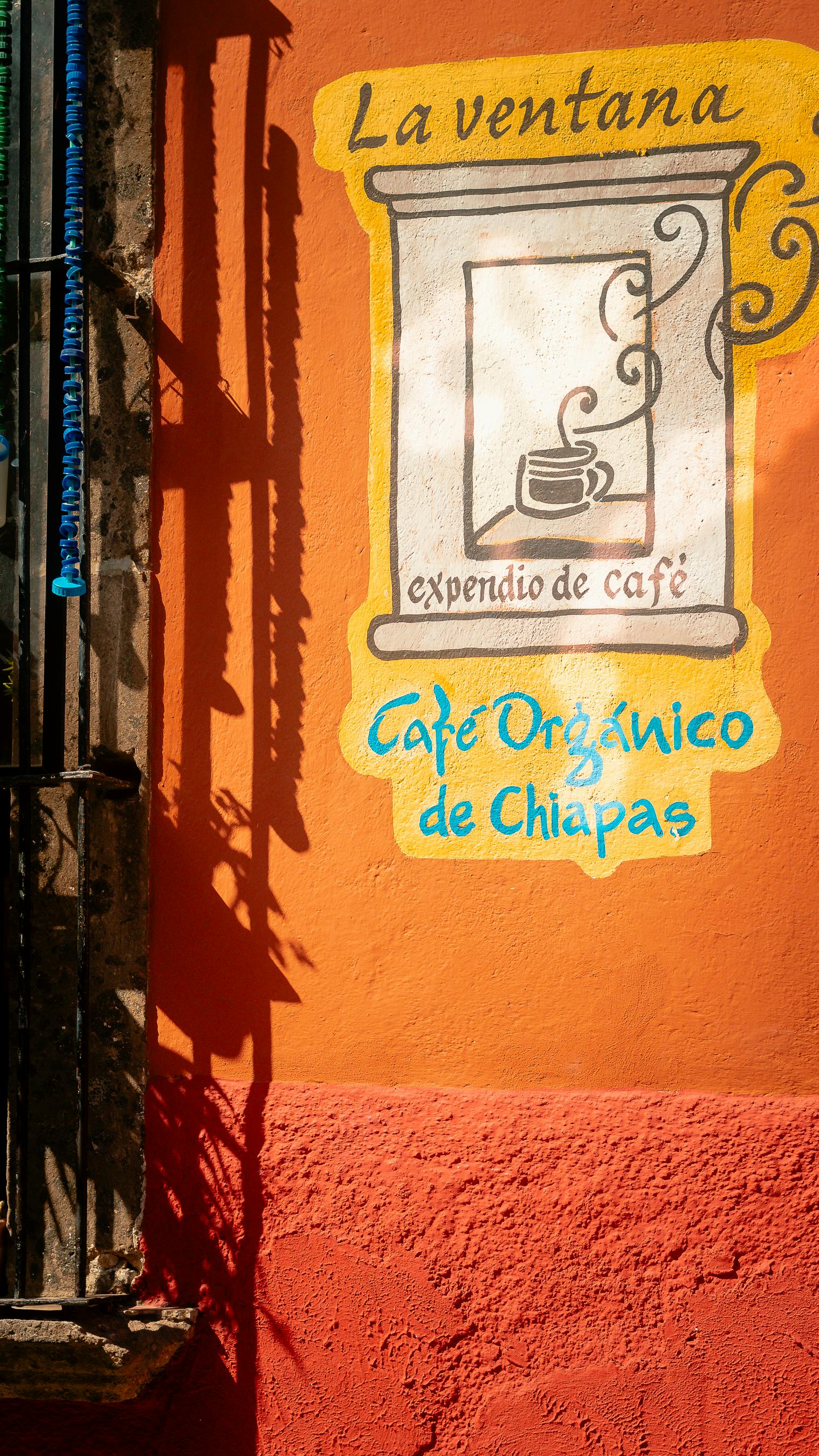 Vibrant cafe sign on an orange wall in San Miguel de Allende, México.