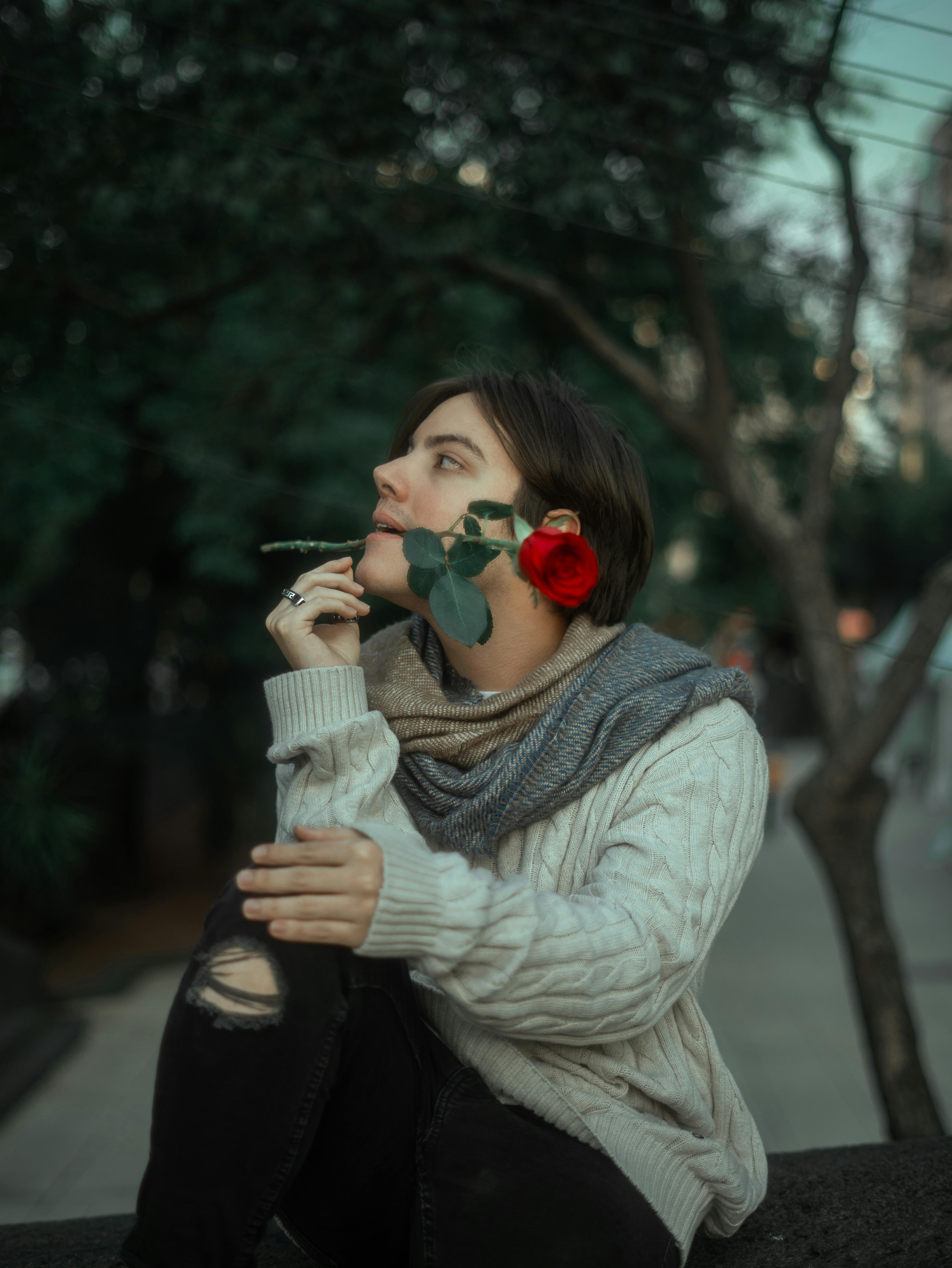 bezplatná Mladá žena s růží kontempluje v klidném parku Mexico City, ztělesňuje lásku a reflexi. Základová fotografie