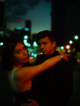 Couple embracing under city lights in a romantic evening setting in Mexico City.