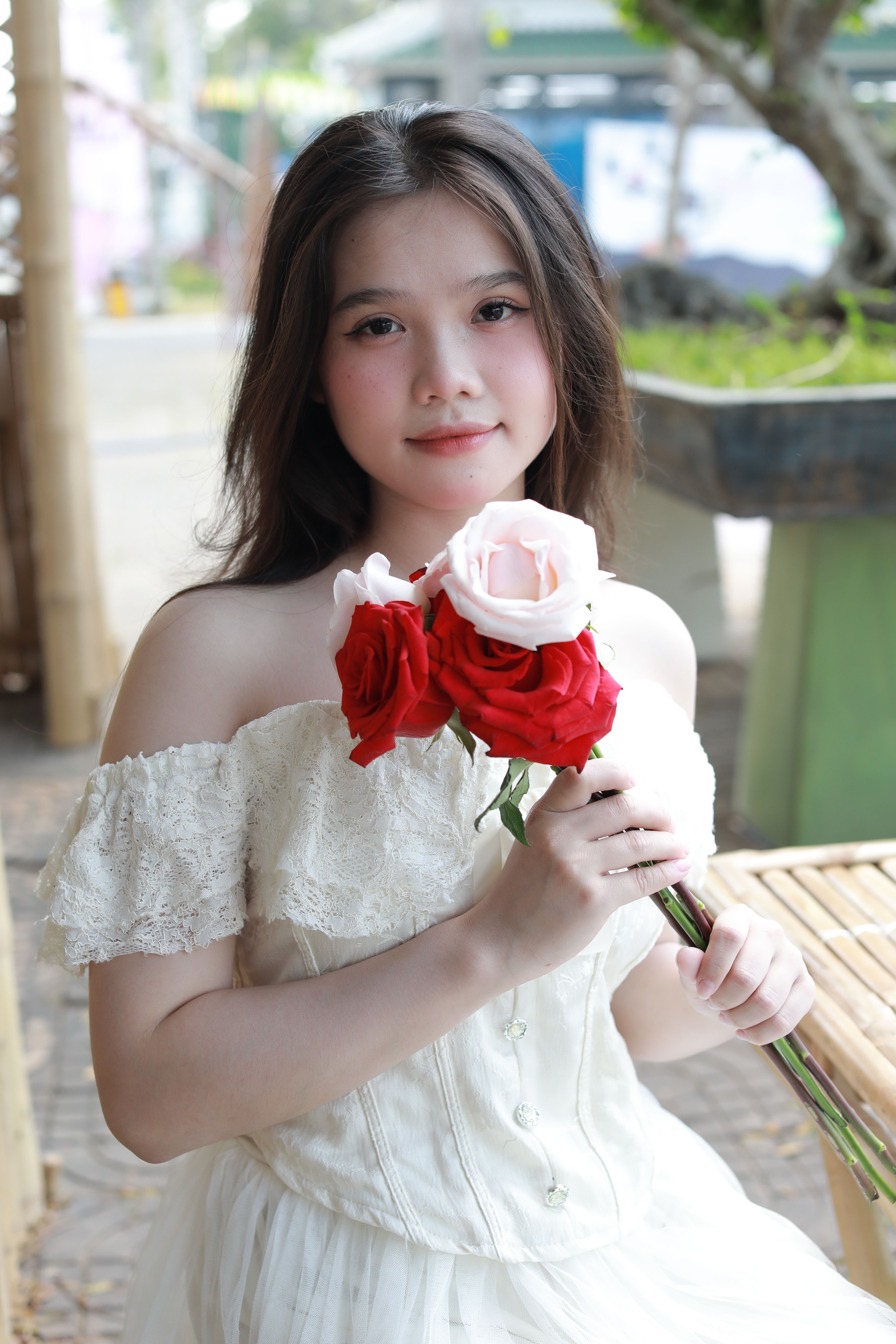 Young woman with roses smiling outdoors · Free Stock Photo