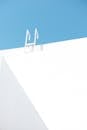 Minimalist White Wall and Ladder Against Blue Sky