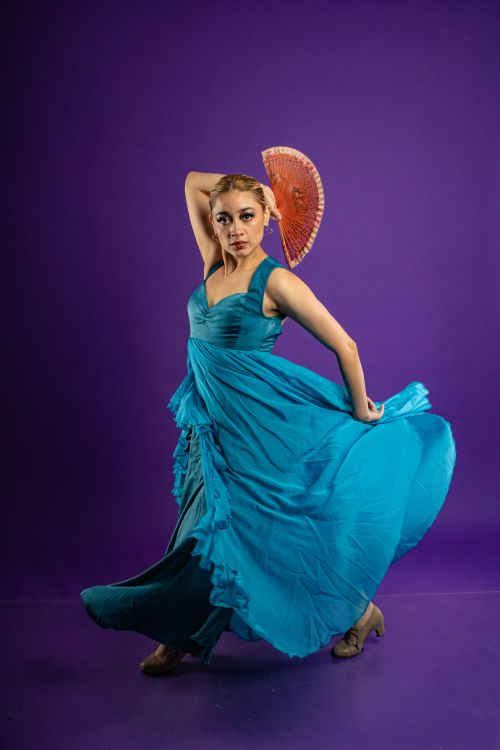 Free Elegant flamenco dance performance with a vibrant red fan and flowing blue dress. Stock Photo