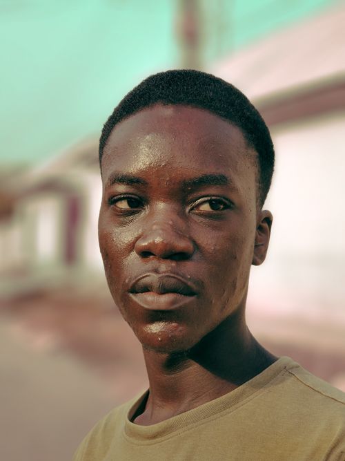 Free Close-up portrait of a young man looking away with a blurred outdoor background. Stock Photo
