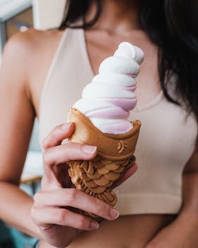 Close-up of woman holding taiyaki ice cream cone outdoors. Perfect summer treat.