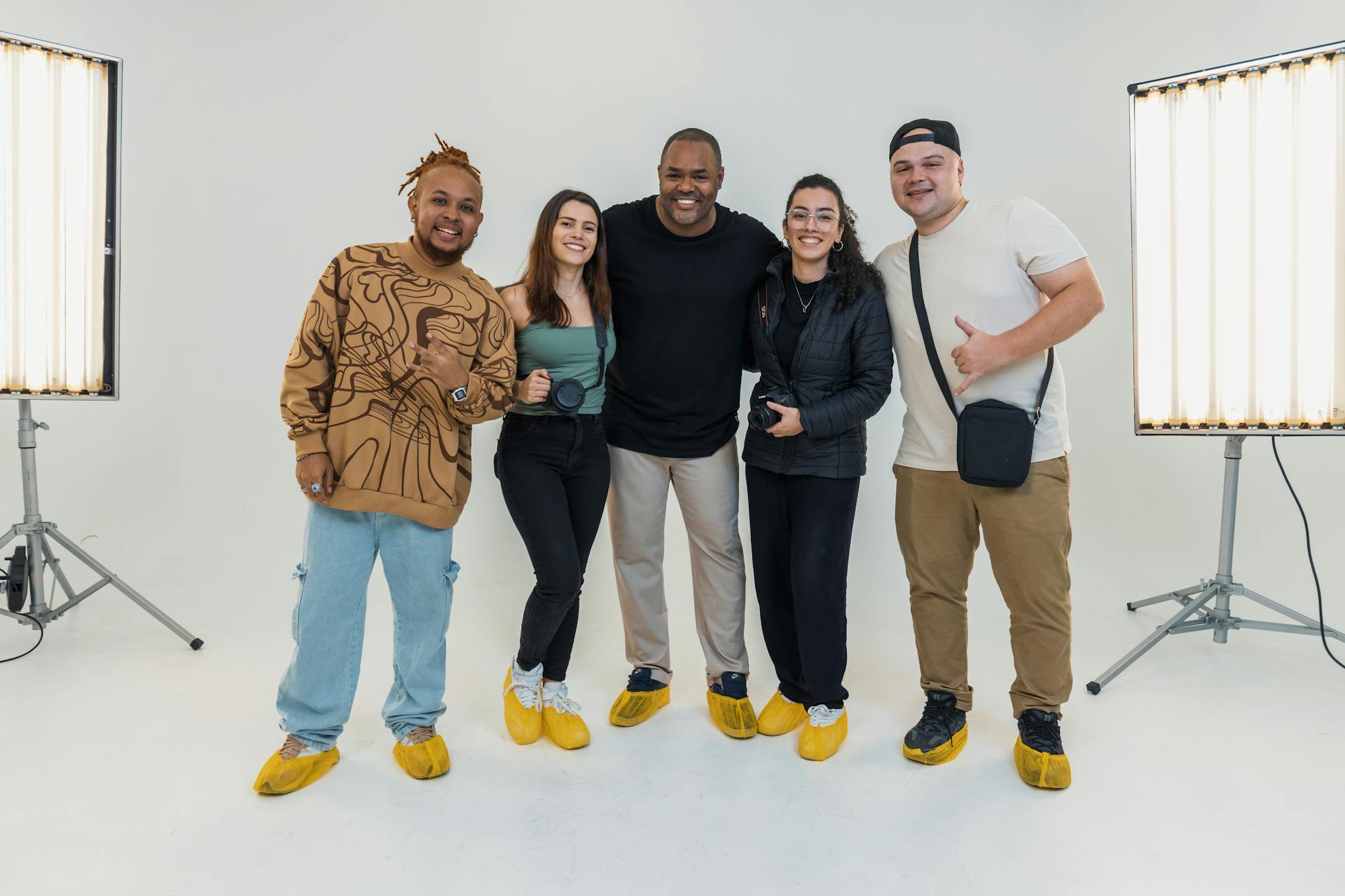 Five adults smiling in a modern photography studio with lighting setup.