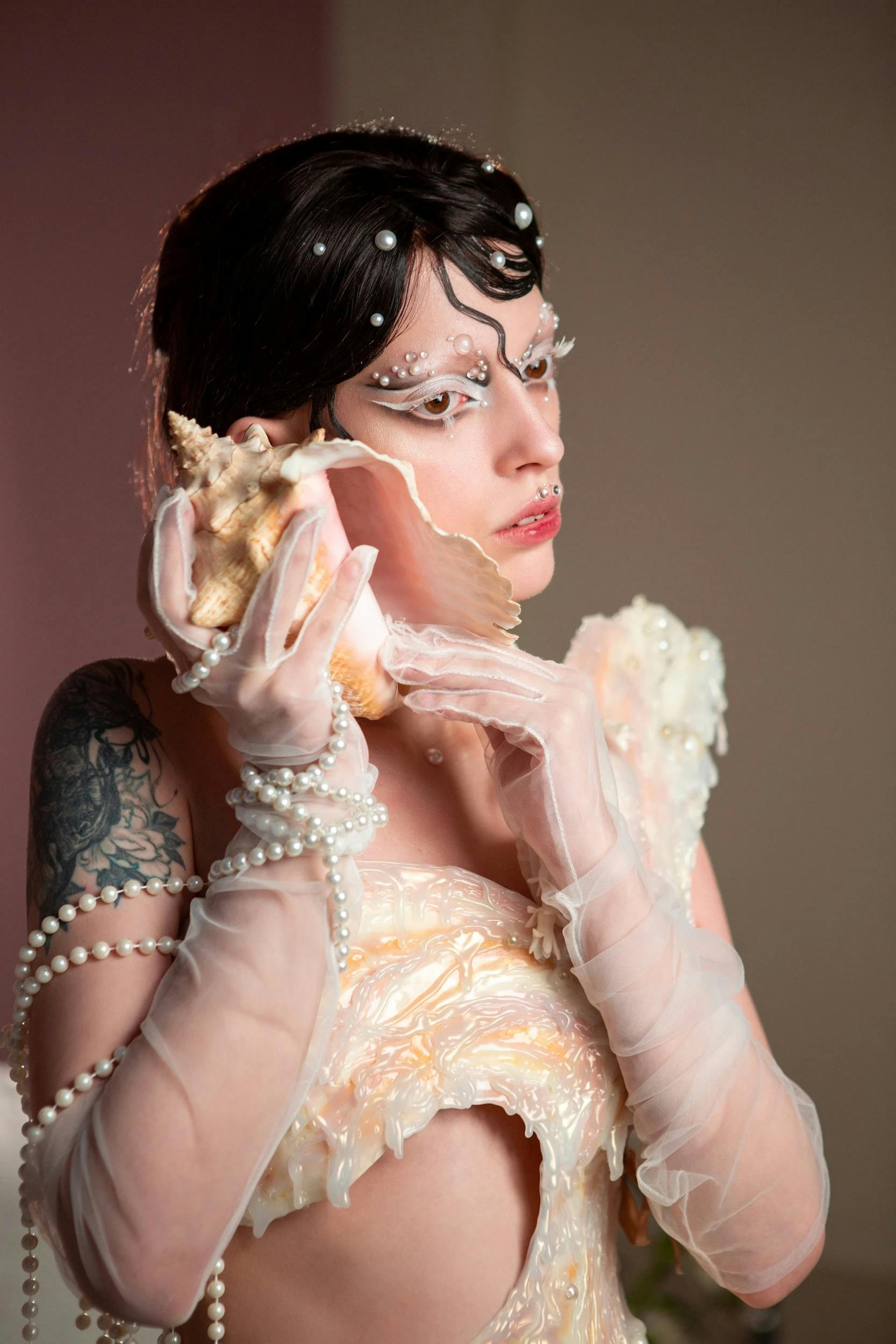 Elegant fantasy portrait of woman holding seashell, evoking mythical mermaid theme.