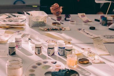 Printed pages and pigment pots spread across a table — photo by Sedanur Kunuk on Pexels